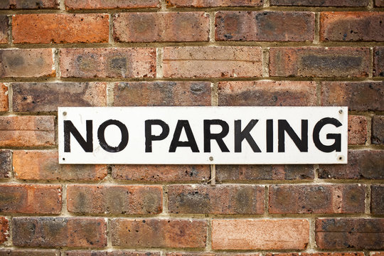 Street Sign Indicating There Is No Parking On The Brick Wall. Selective Focus