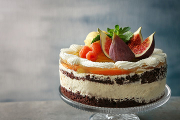 Delicious creamy cake with figs and berries on light grey background