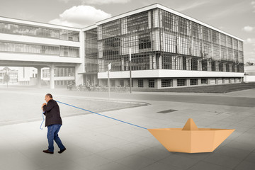 Man pulling paper boat