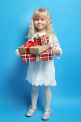 Little beautiful girl holding a gift box.