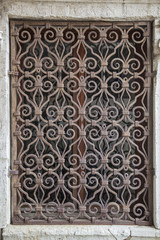 Old window with metal forged carved lattice, Venice