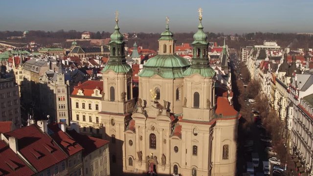 The Church of Saint Nicholas and tiled roofs old town in Prague on a sunny day, Czech Republic. 4K video