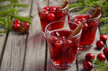 Cranberry drink on wooden background with fir branches and fresh berries, selective focus