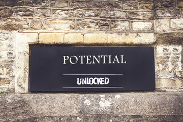 Sign indicating that potential is unlocked on the old brick wall. Filter applied. Selective focus