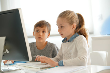Kids in computer lab working on desktop computer