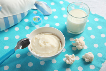 Bowl with healthy baby food on table. Child feeding concept