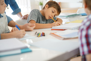 Kids writing notes in classroom