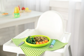 Highchair with healthy baby food at home. Child feeding concept