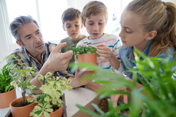 Teacher with kids in biology class learning about plants © goodluz