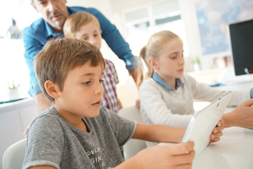 Kids in classroom learning with digital tablet