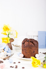 Easter orthodox sweet chocolate bread and colorful quail eggs on white background. Easter holidays breakfast concept with copy space.