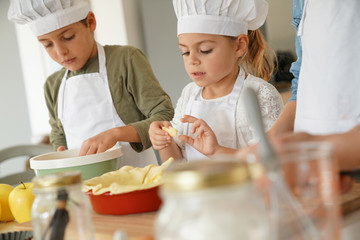 Kinder im Kochkurs-Workshop, der Apfelkuchen zubereitet