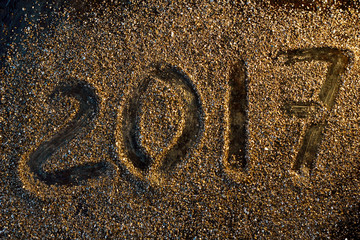 2017 new year concept. Numbers 2017 on the gold sand texture.