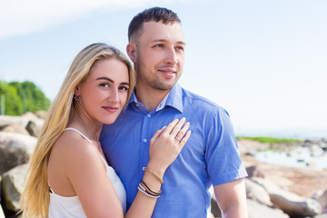 portrait of beautiful couple posing on rocky beach
