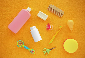 Baby's accessories on yellow fabric background, top view
