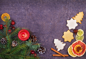 Christmas background with gingerbread cookies, dried citrus and fir tree. Decorations and gift box on rustic wooden board. View from above, top studio shot