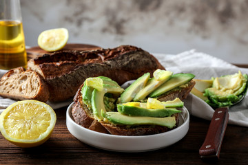 Delicious bruschetta with avocado and lemon on table