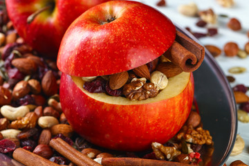 Red juicy apple with assorted nuts , raisins and cinnamon