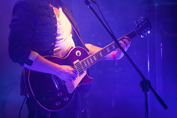 Fototapeta na wymiar Electric guitar player in blue light