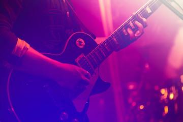Obraz na płótnie Canvas Electric guitar player in colorful lights
