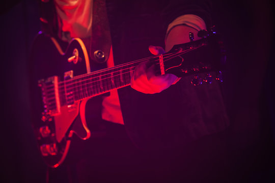 Guitar player on a stage with red light