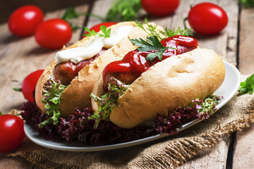 Hot dog with ketchup and mayonnaise, vintage wooden background,