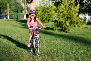 Fototapeta premium happy child girl riding bicycle in summer sunset