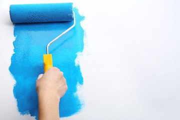 Decorator's hand painting wall with roller