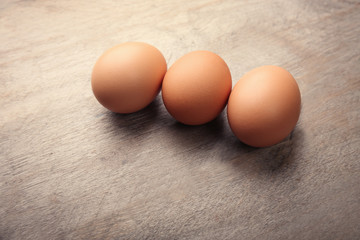 Raw eggs on wooden background
