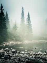 Obraz premium Piękne górskie jezioro we mgle w Tatrach na Słowacji. Styl retro o niskim nasyceniu
