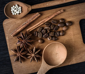 Fototapeta na wymiar coffee, star anise, cinnamon, spoon on wooden cutting Board and dark background