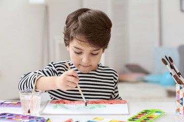 Cute little boy painting, on blurred background