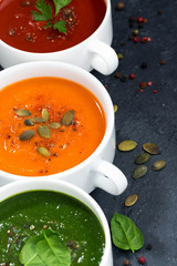 assortment of fresh vegetable cream soup on a black background