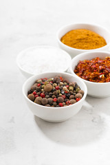 assortment of pepper, salt and spices in bowls, vertical closeup