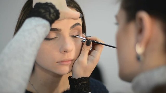 makeup artist makes models eye makeup