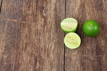 lemon fresh green and slice lime on wooden table, top view