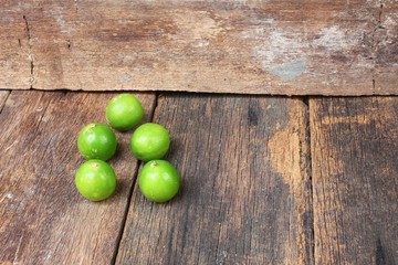 lemon with green on the wooden table, top view