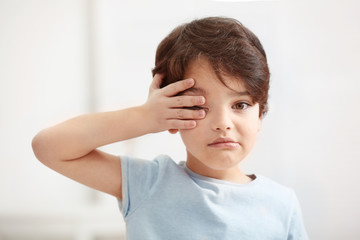 Cute emotional little boy on light blurred background