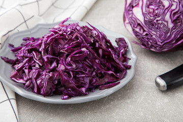 Shredded red cabbage in clay bowl on stone background. Vegetaria