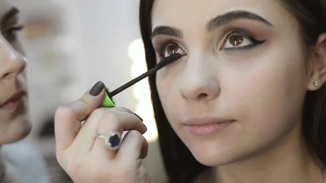makeup artist makes models eye makeup close up, slow motion