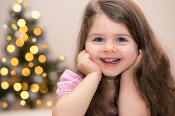 Charming little girl in front of Christmas tree