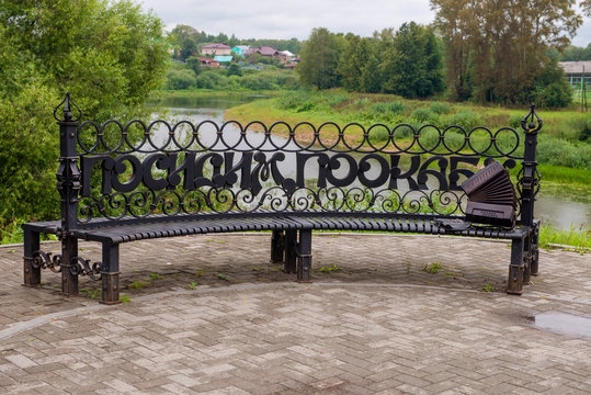 Forged bench with the inscription "Sit, pookaem" on the embankment rivers and view of the Church Candlemas of the Lord