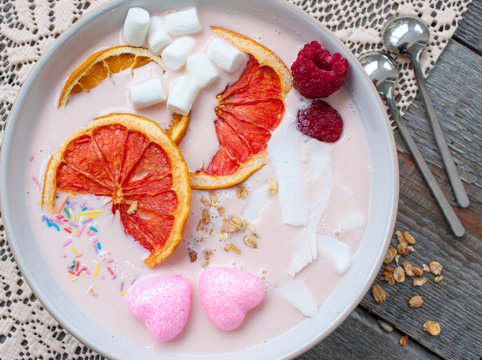 Pink smoothies with raspberry, coconut, oranges and granola.  Breakfast on Valentine's Day.