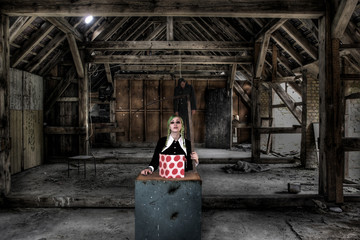 Junge Frau in Gothic Schulmädchen Kostüm mit Sense
