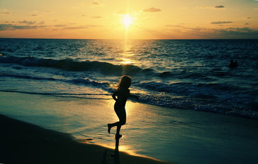 kids playing on the beach at sunset