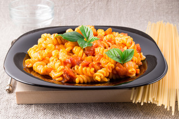 Cooked pasta girandole on a black plate