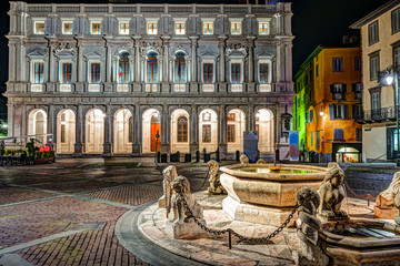 Piazza Vecchia, Citta Alta, Bergamo, Italy. Night view on the square with the beautiful fountain in...