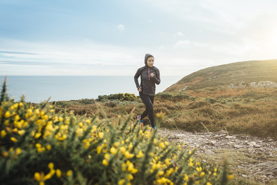 Ireland, Howth, woman running on coastal path