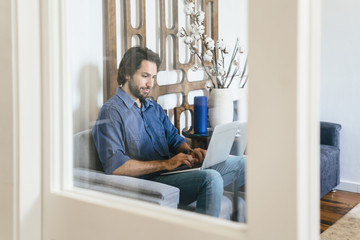 Businessman sitting in office lounge, using laptop