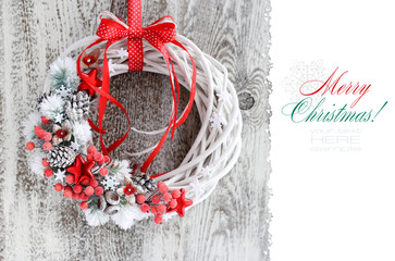 Christmas wreath with red ribbon on a vintage wooden background. Copy space. Beautiful Christmas Background